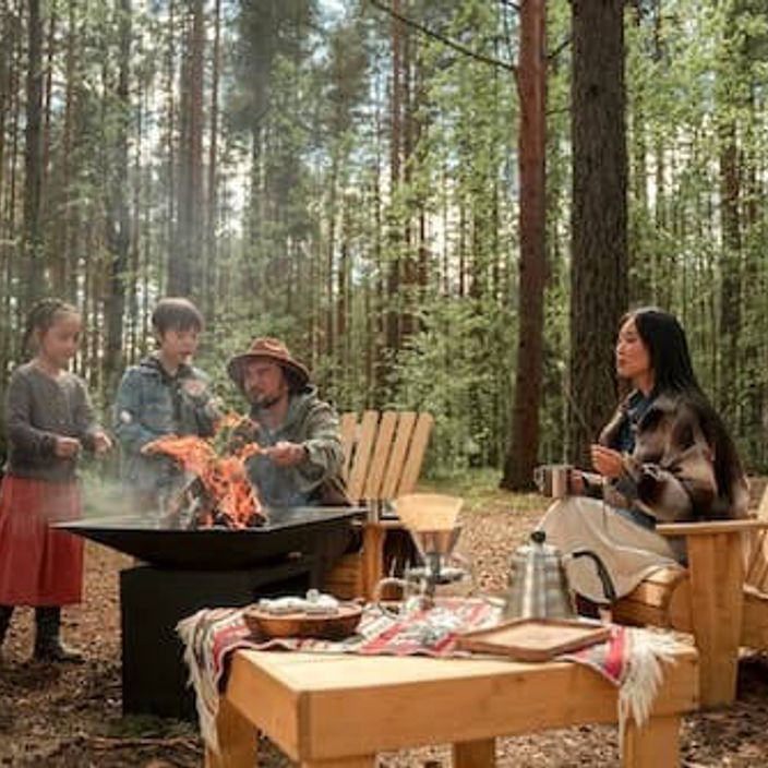A family of 4 roasting marshmallows at a camp fire