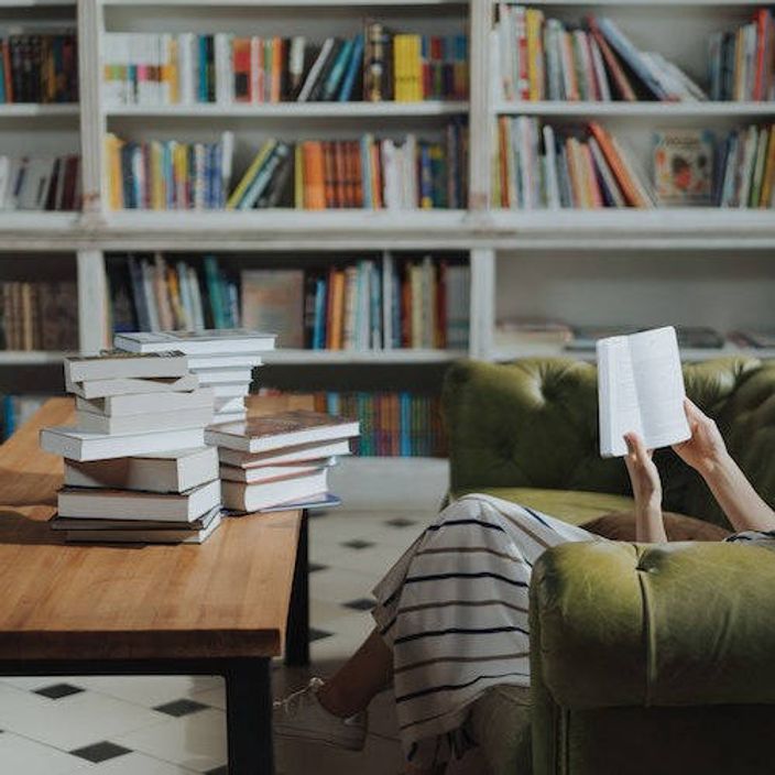 A women reading a book on the sofa