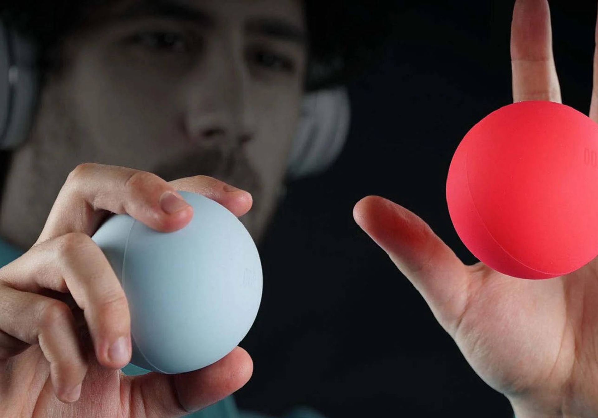 a guy playing music while holding his odd balls