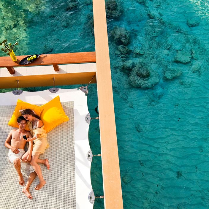 couple lying on net overlooking the sea in the Maldives