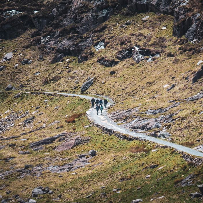 family walking through waterfall in wales