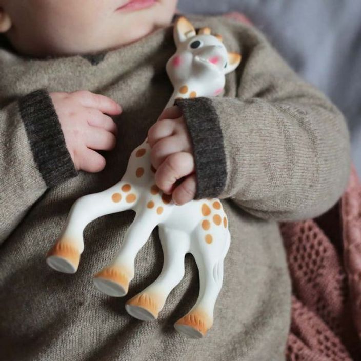 Sophie la girafe® being held by a baby