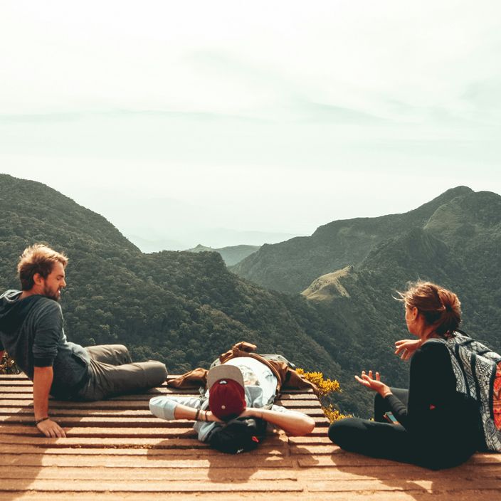 Group of young people standing looking up at nature with backpacks on