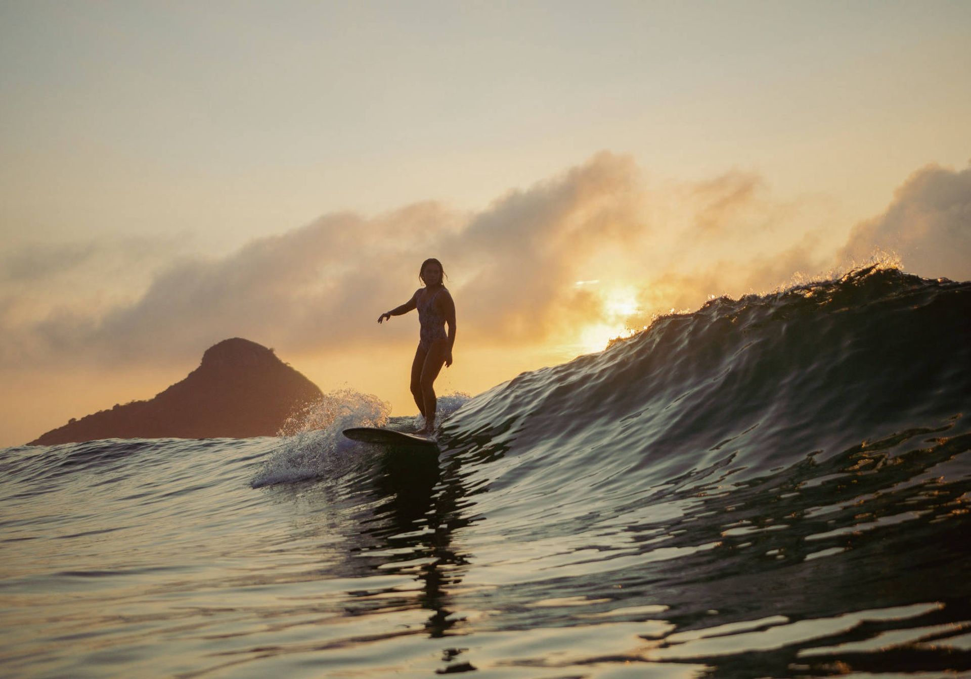 Girl surfing at sunset