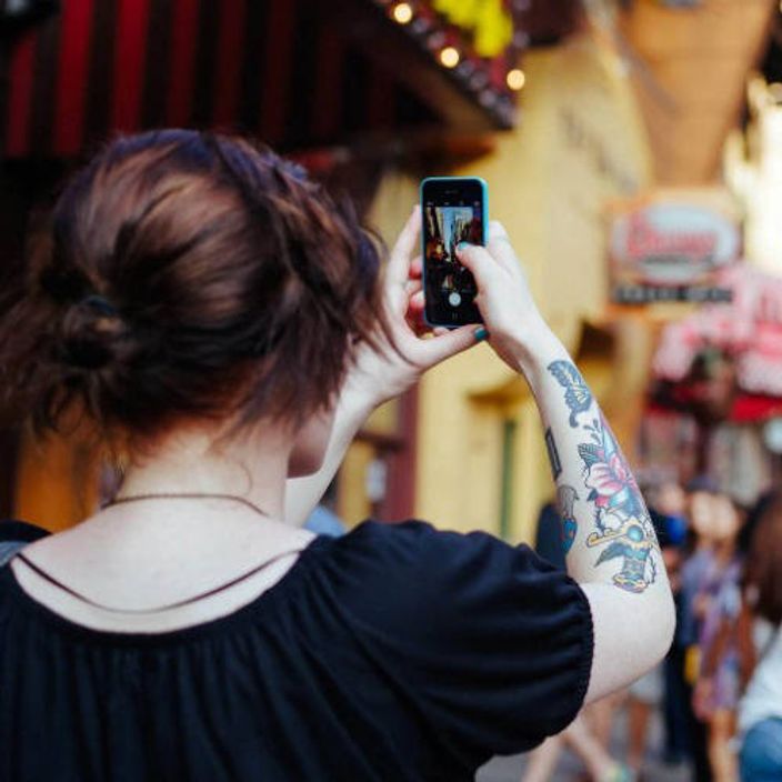 Woman taking picture with iPhone