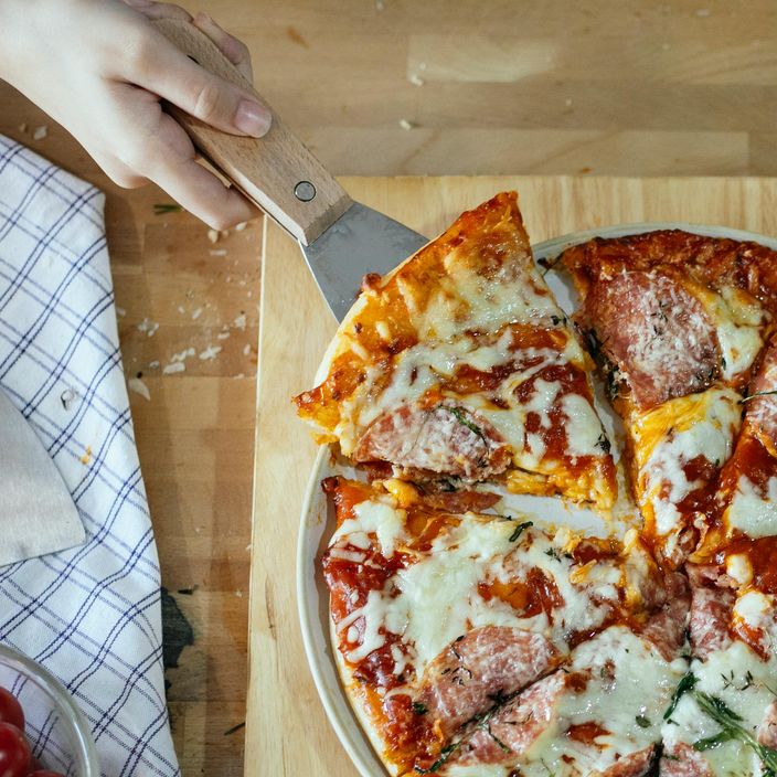 Woman holding pizza on a board
