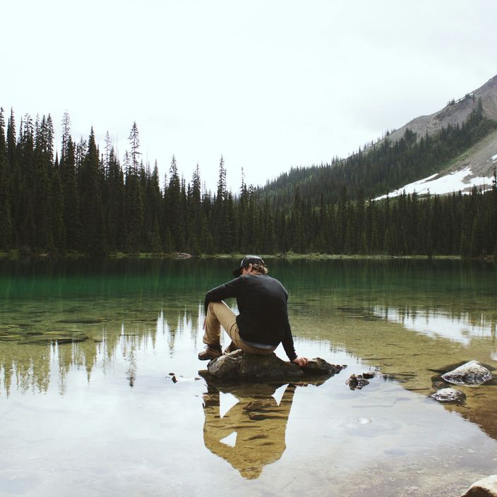 A guy sits on a lake in Yoho