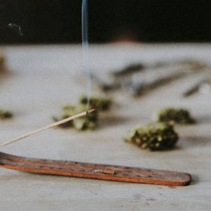 a burning incense stick surrounded by moss