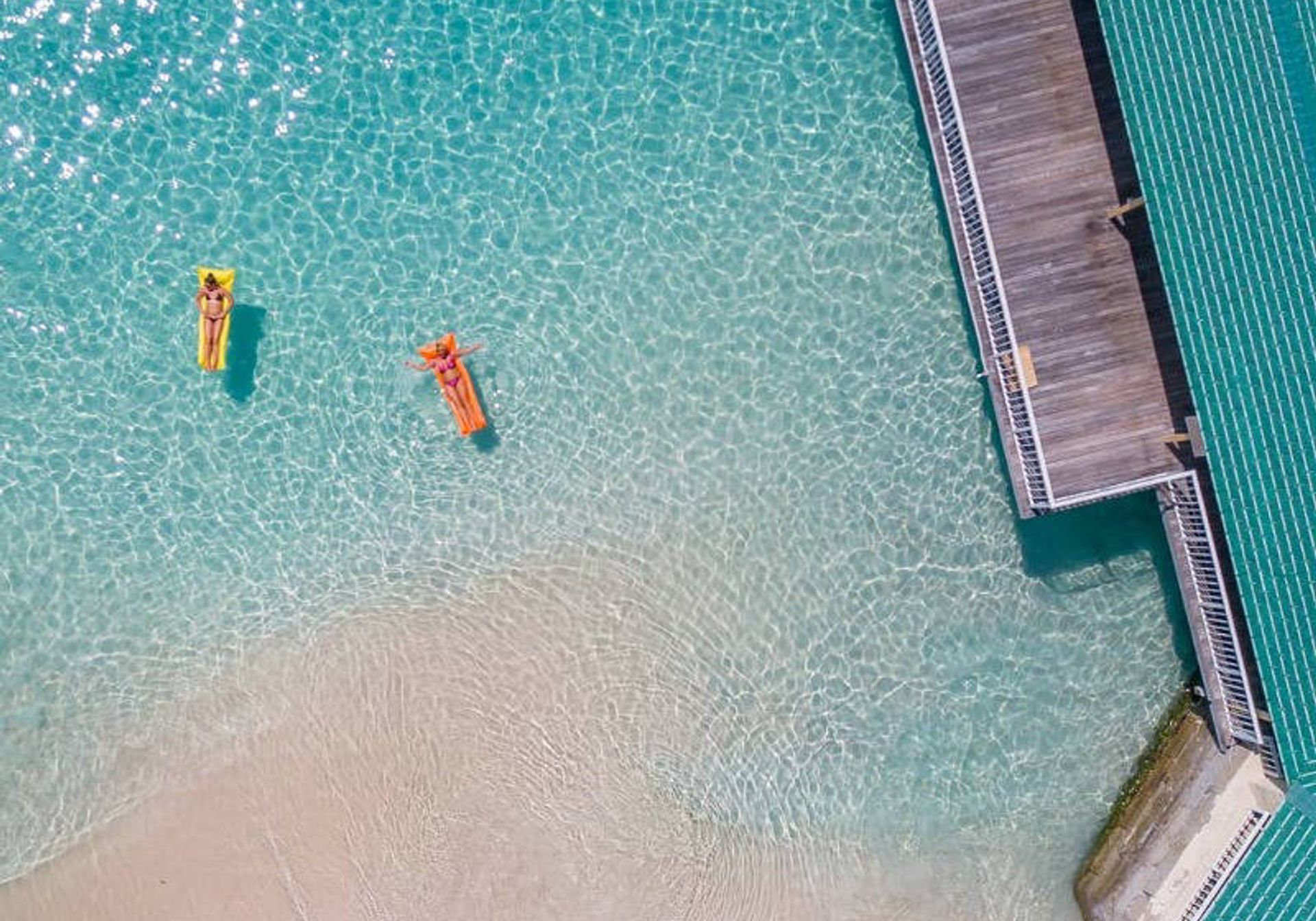 women floating in clear sea