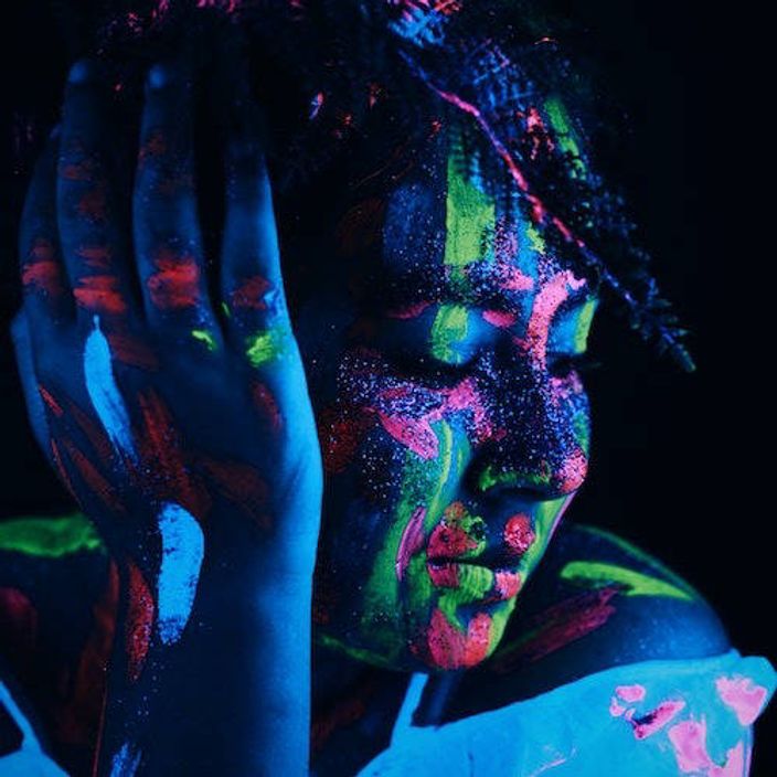 A woman with uv paint on her face that glows in the dark
