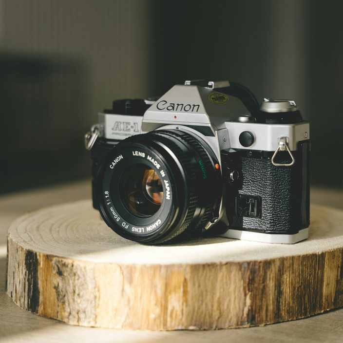 Guy wearing the Canon AE-1 camera strapped to him