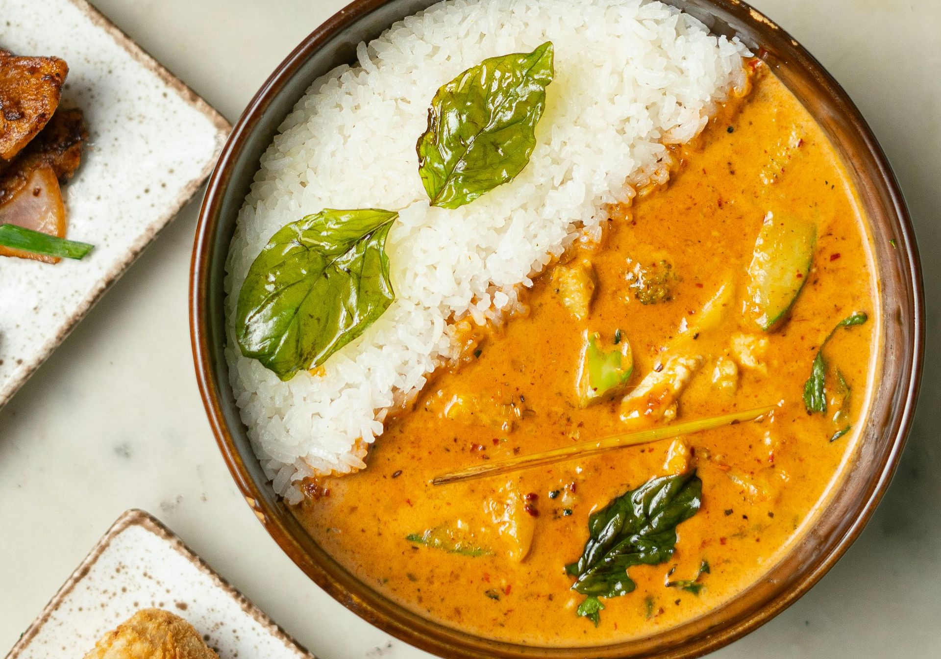 Founder of Cook Eat Joy, Ela wearing a yellow branded apron while cooking
