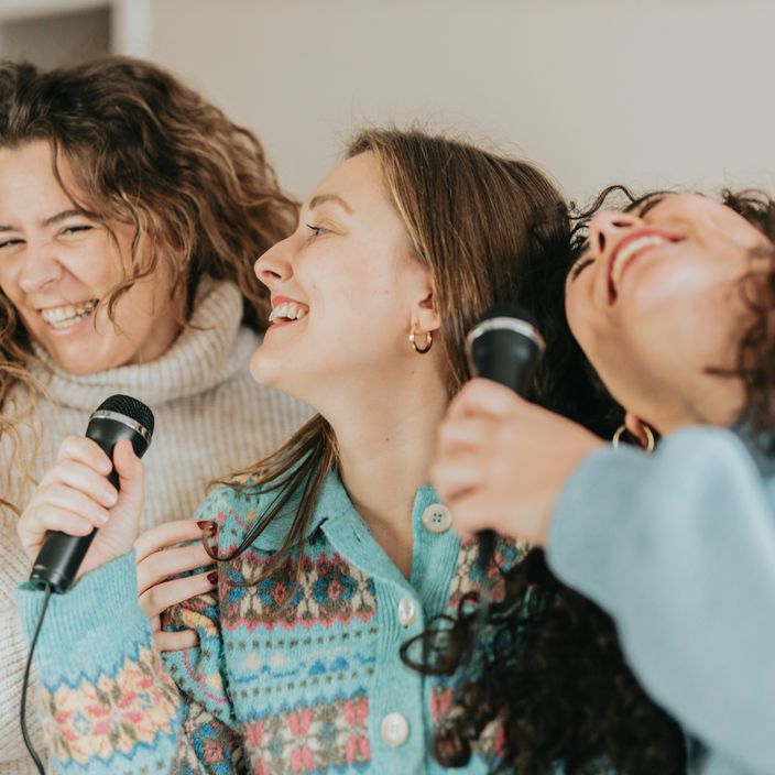 A group of women singing karaoke