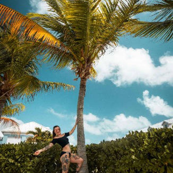 Girl poses by palm tree in Turks & Caicos