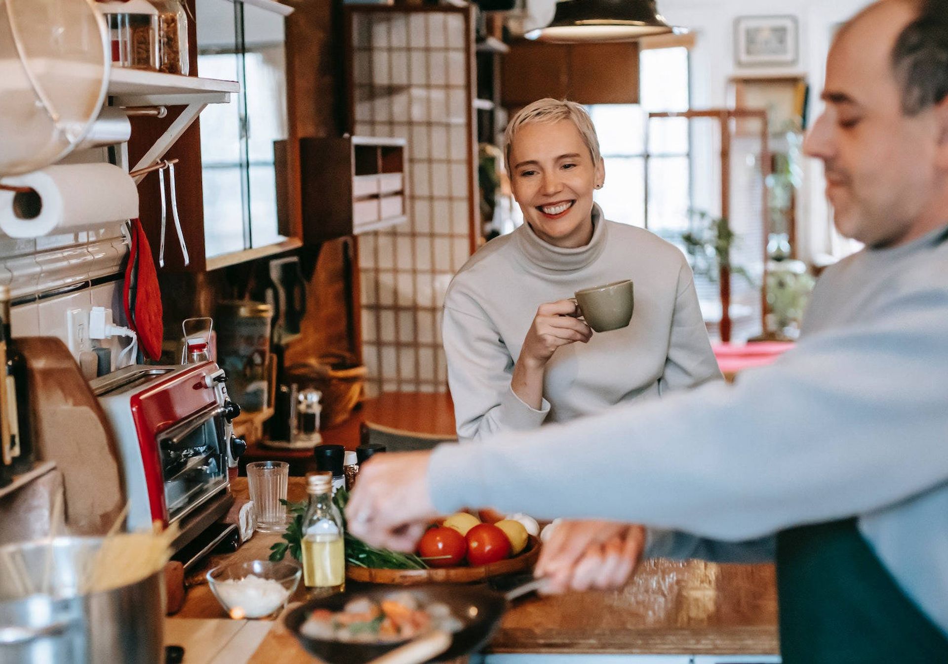 A man cooking lunch in the kitchen for his friend