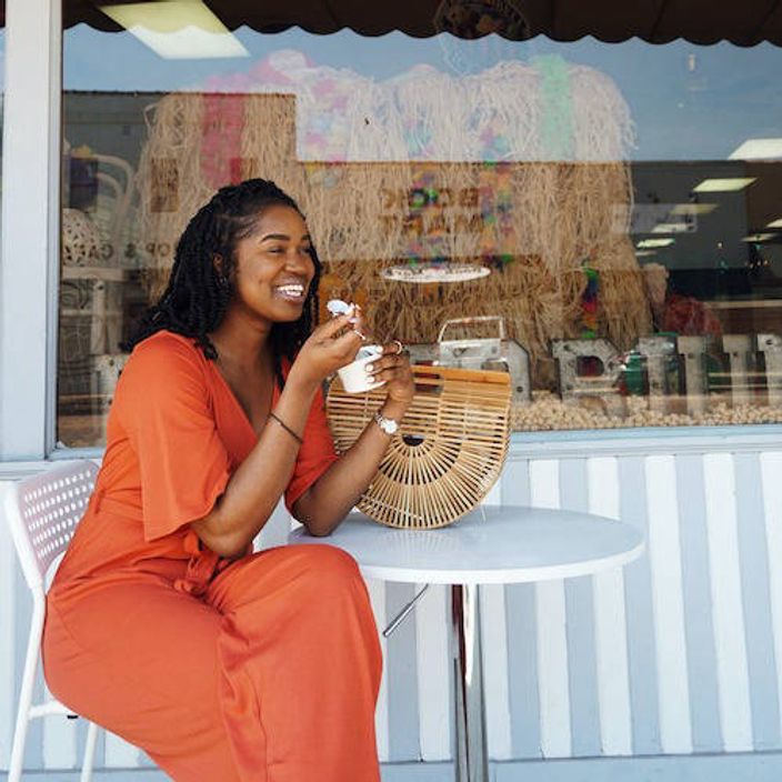 Woman eating ice cream outside café