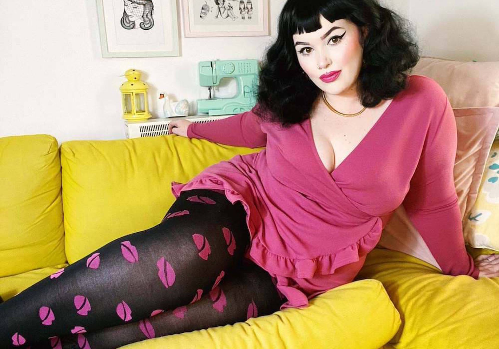 Woman wearing dress and tights on a bright yellow sofa