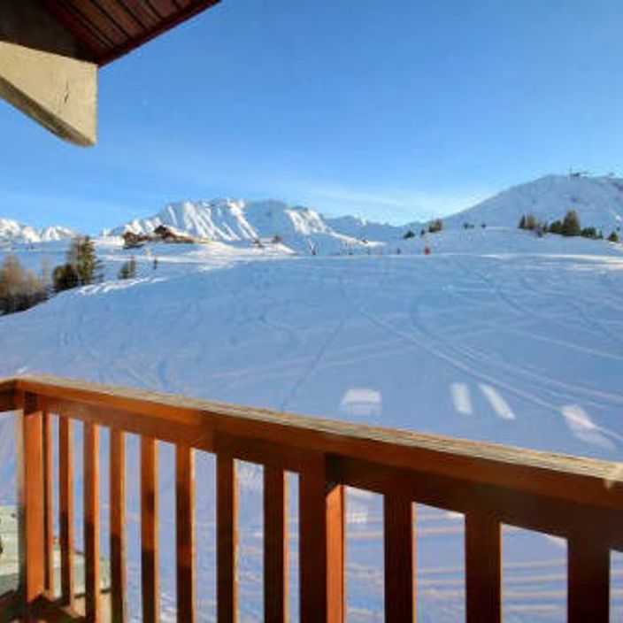 a balcony of a skiing chalet overlooking a snow covered mountain slope