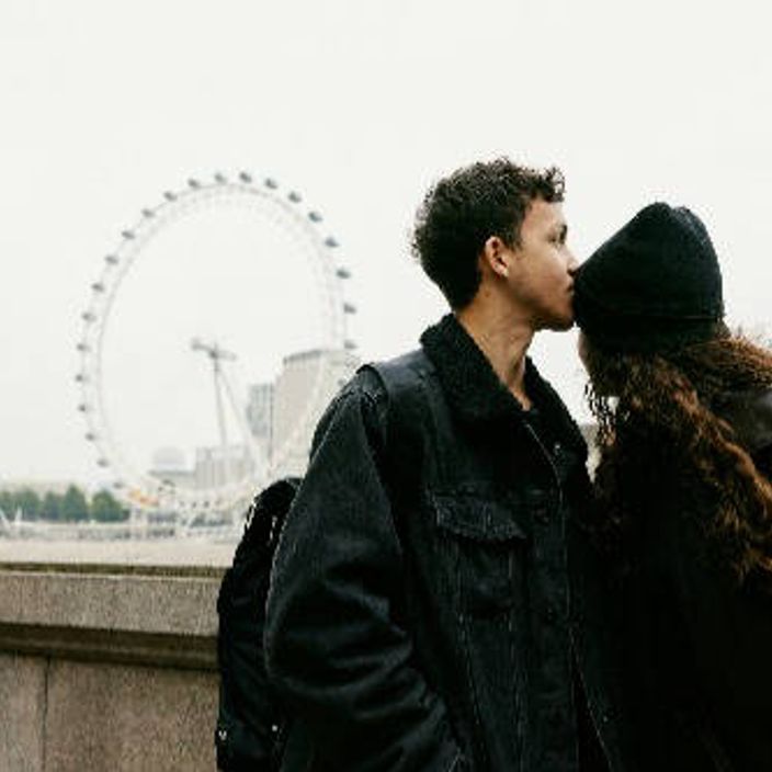 Couple kissing in front of the London Eye