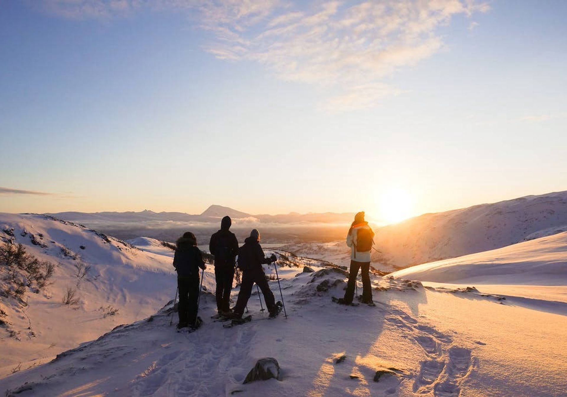 Group adventure skiing trip on snowy mountain watching sunrise