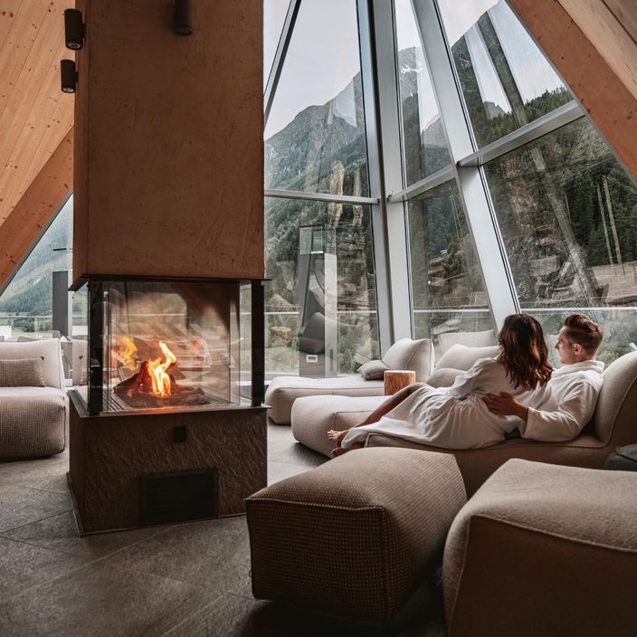 couple by a fire inside the aqua dome hotel in winter
