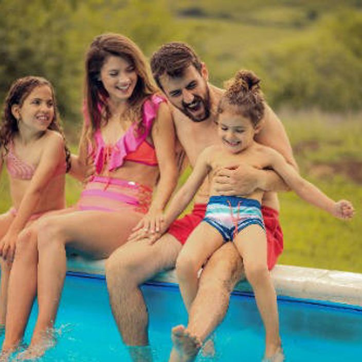 Family sitting around a pool