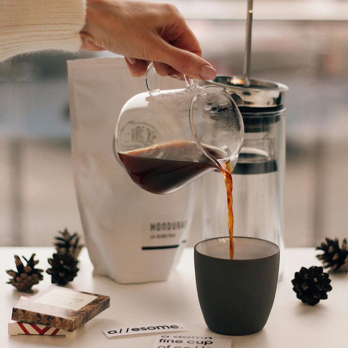 A women drinking coffee stroking her dog