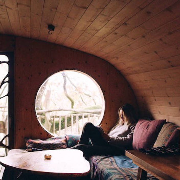 Woman reading in a treehouse