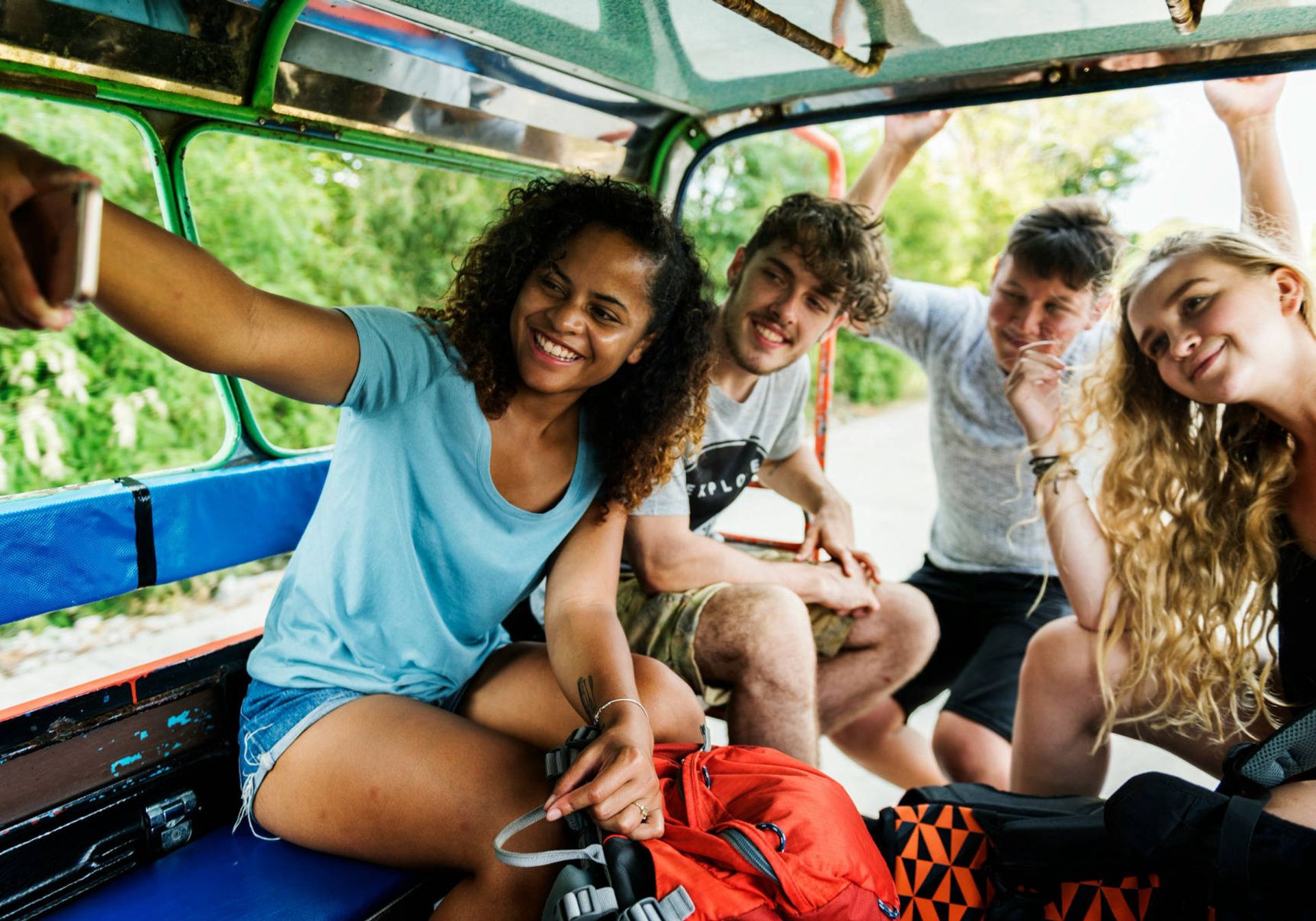 Group of young people take a selfie in the back of a truck