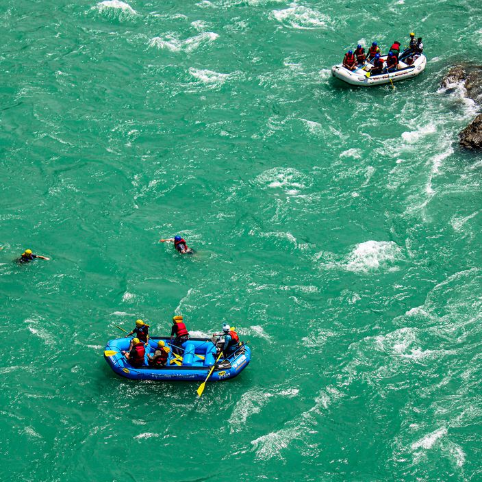 Kid walking through water alongside rocks