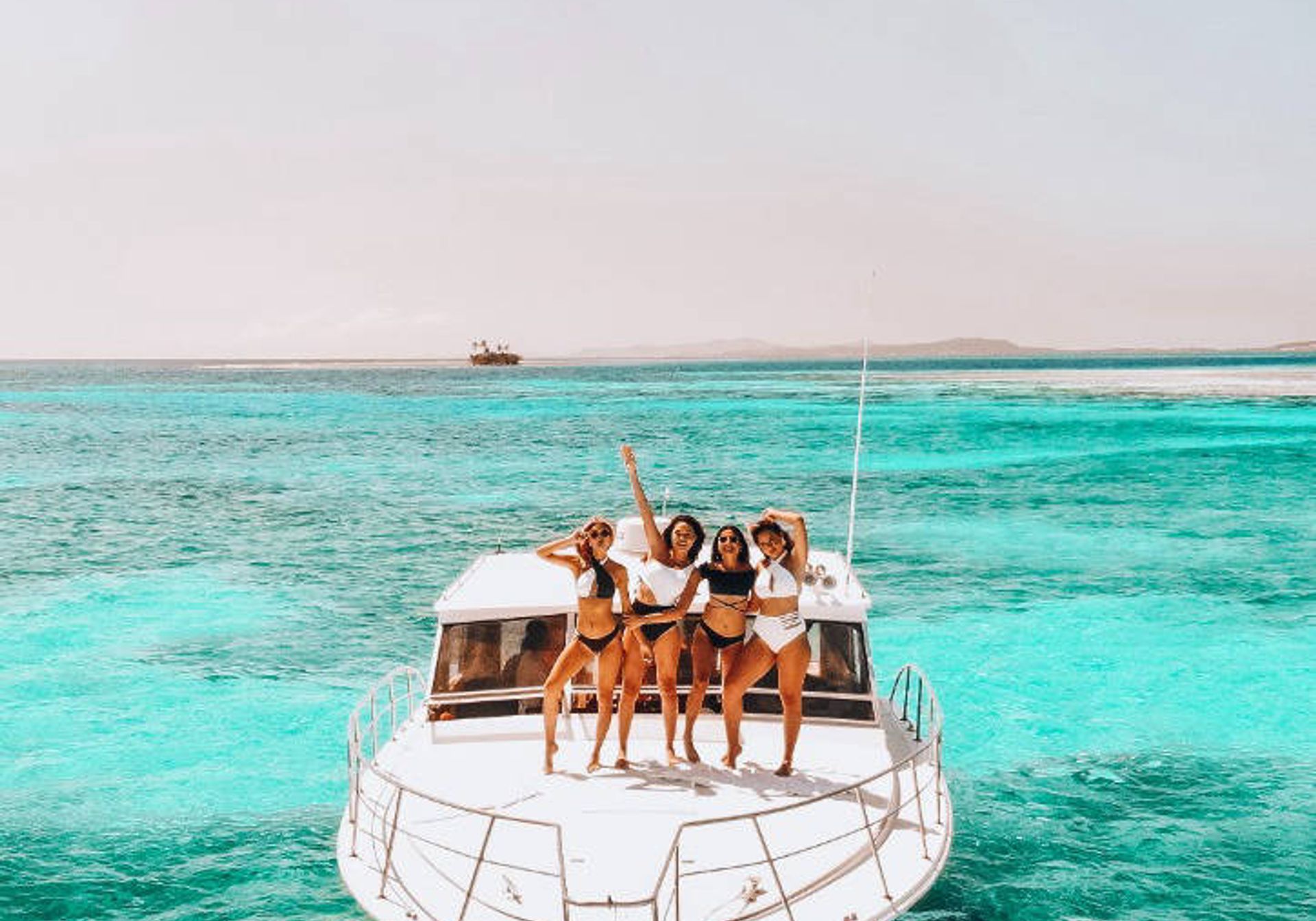 4 girls standing on a yacht