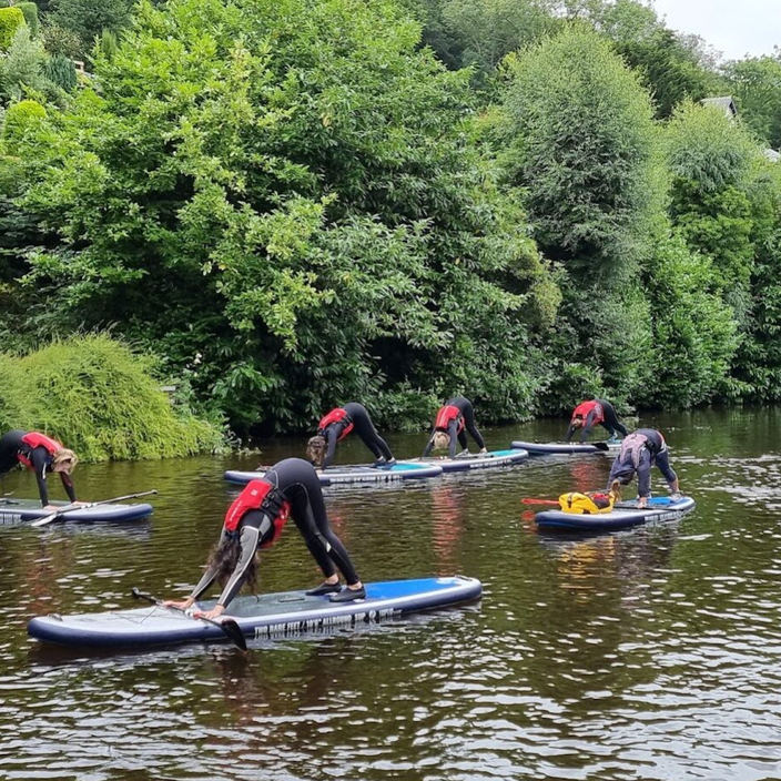 girl standing on paddling board in wales