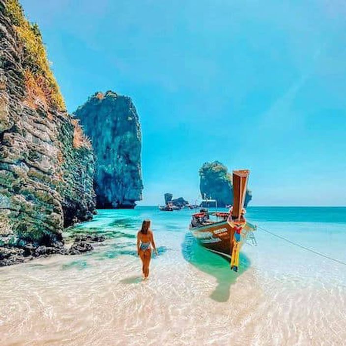 Woman with boat on blue sea in Thailand