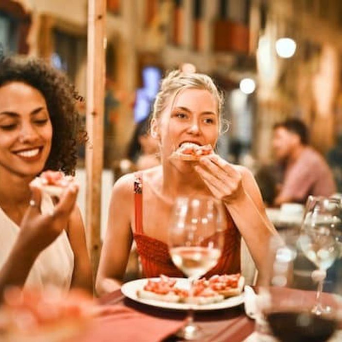 Two friends eating pizza at a restaurant 