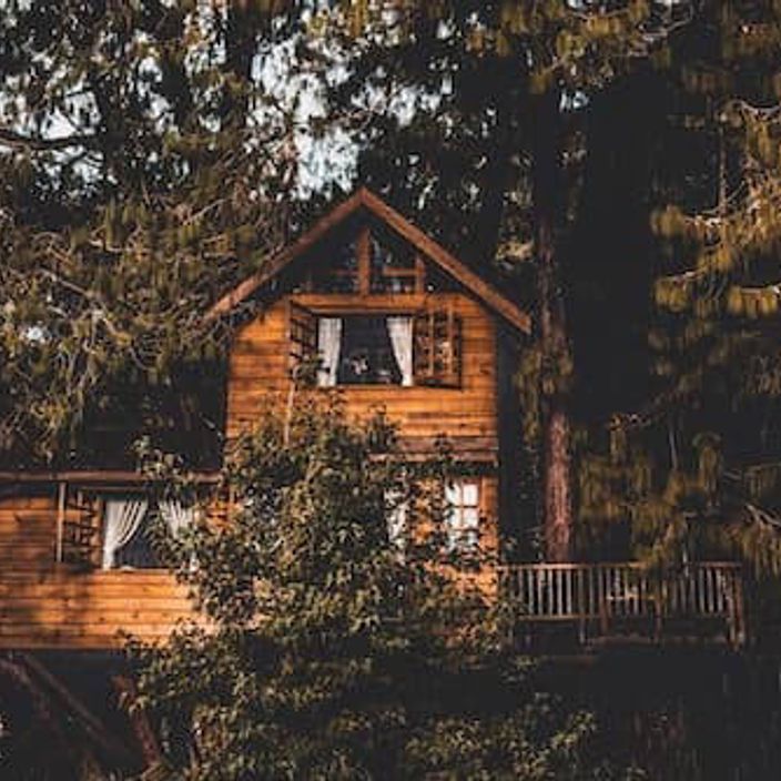 A brown wooden tree house in the woods