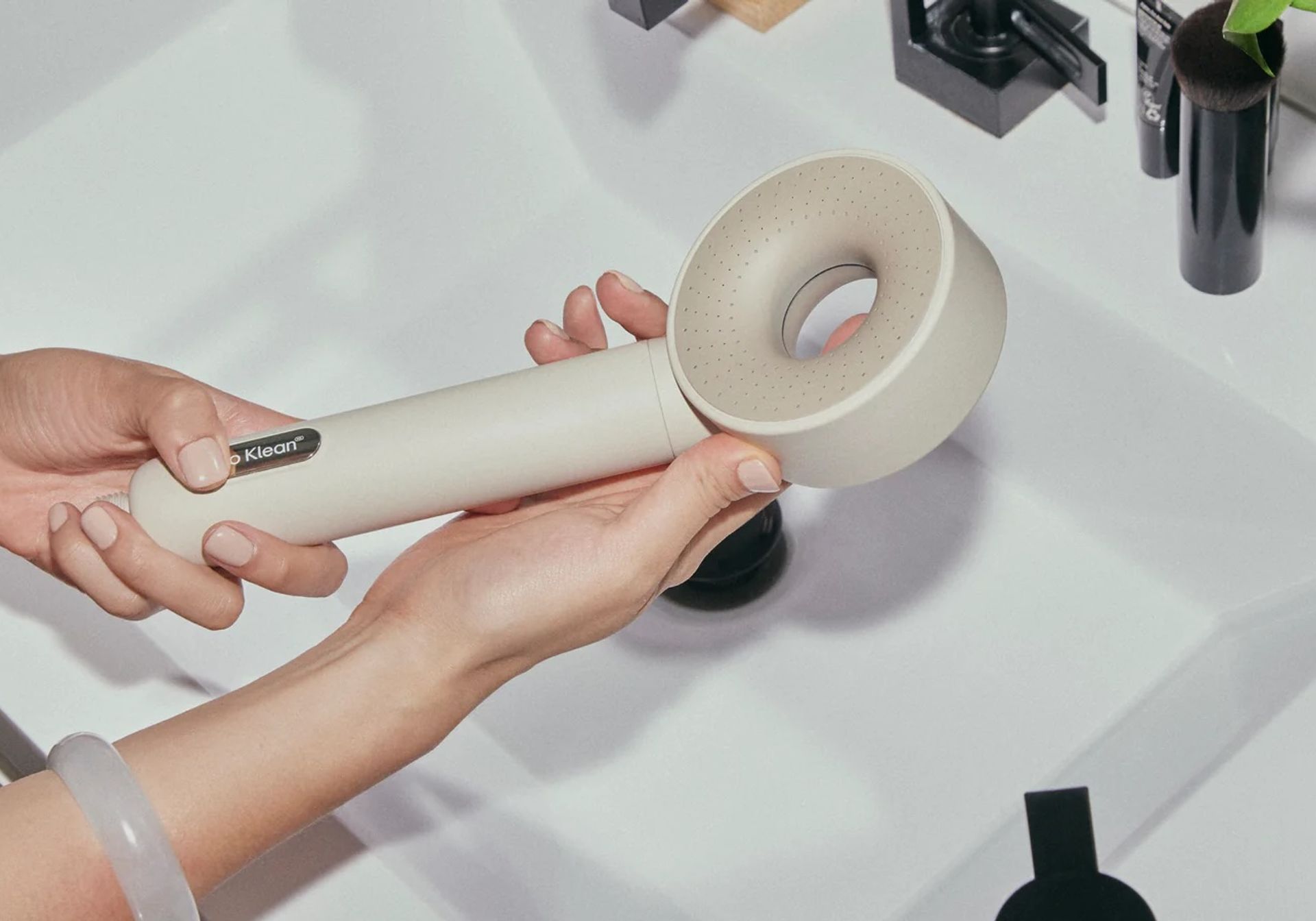 person holding hello klean shower head