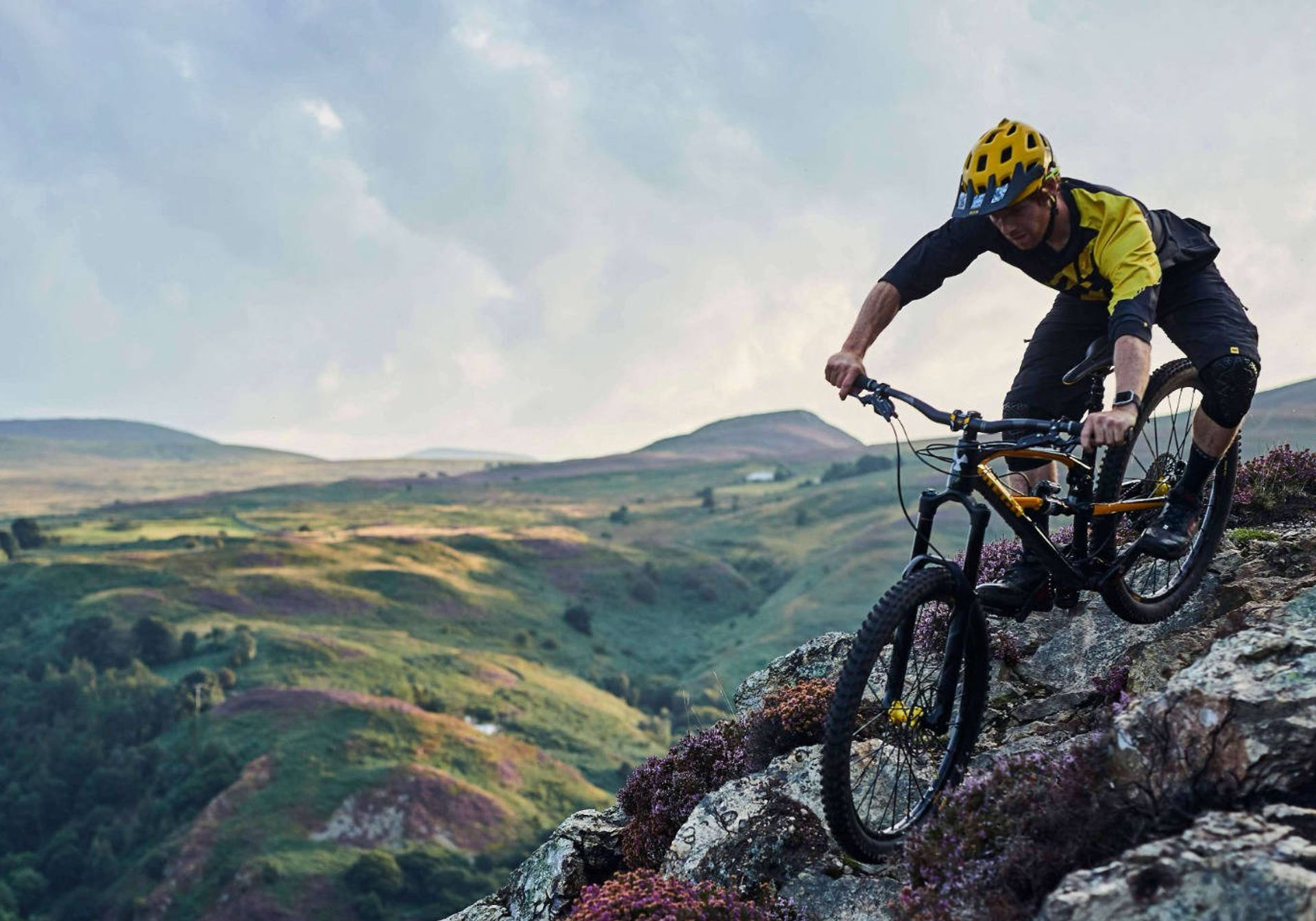 man mountain biking down a cliff in wales