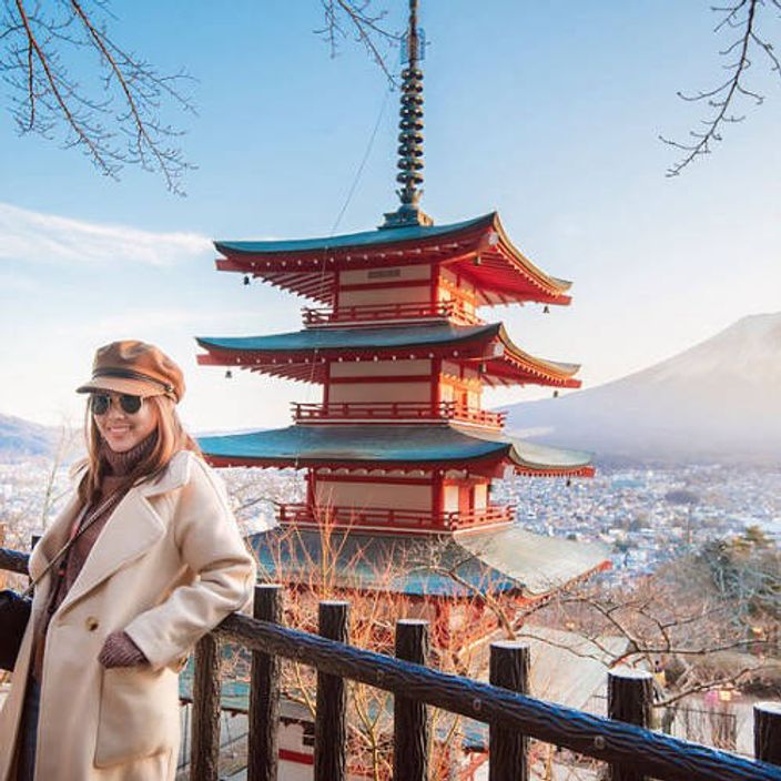Woman at Chureito Pagoda overlooking Mount Fuji