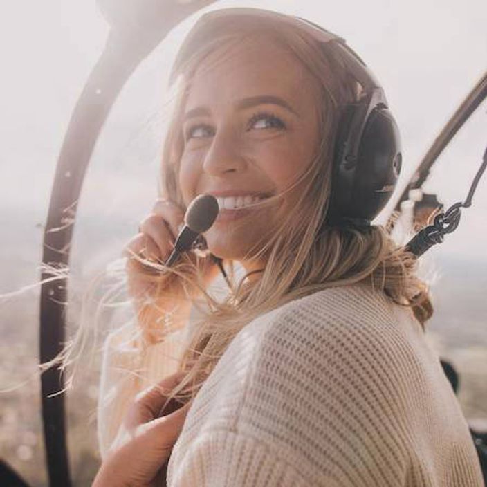 Woman in a helicopter with headset on