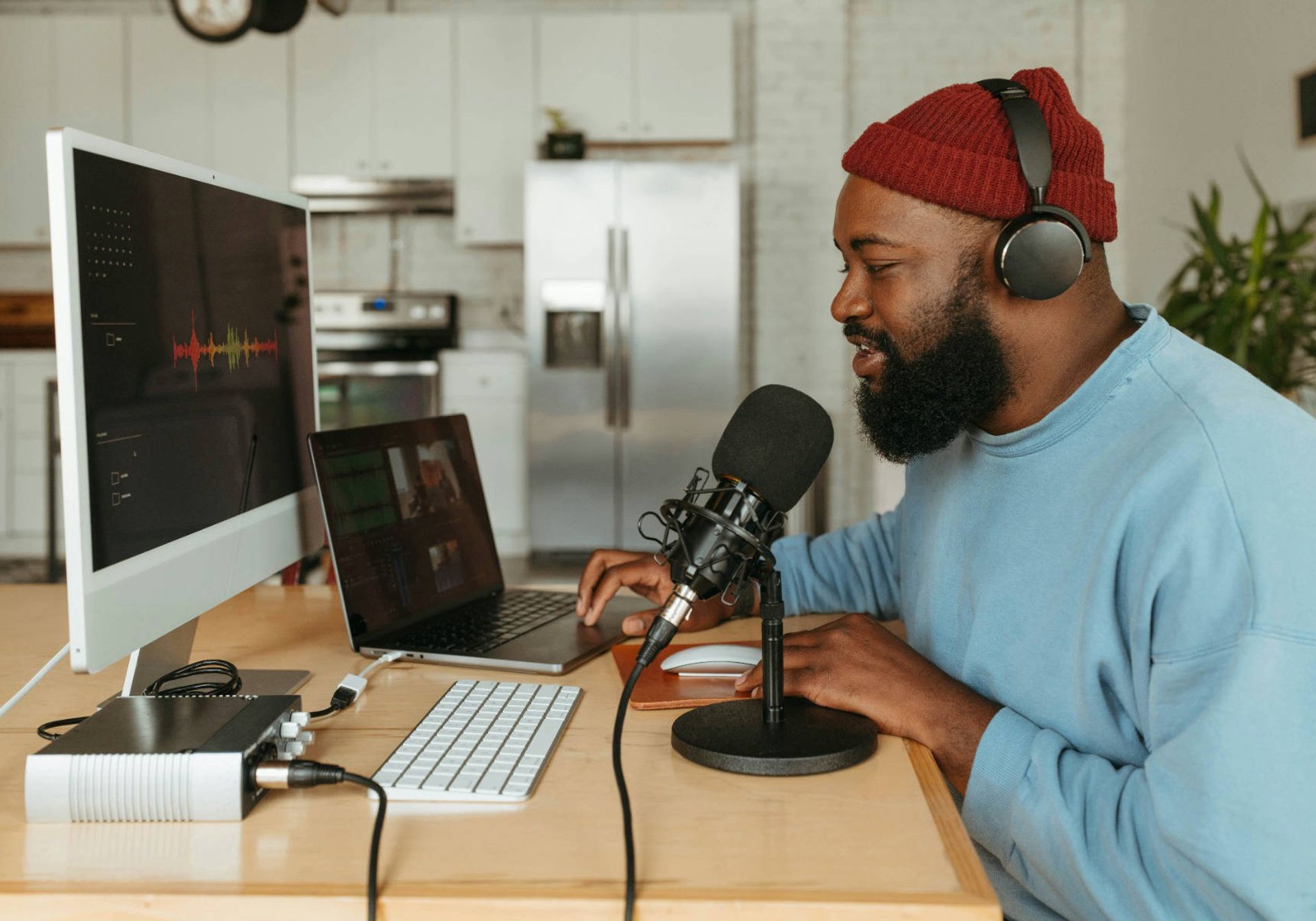 Podcaster on his laptop speaking into a mic