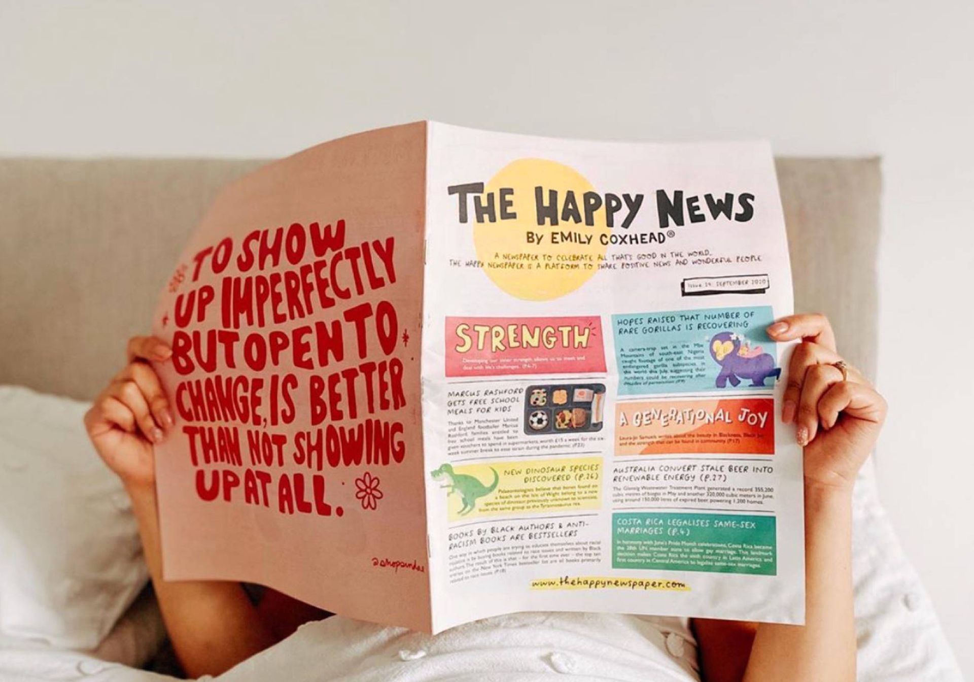 Person reading newspaper in bed