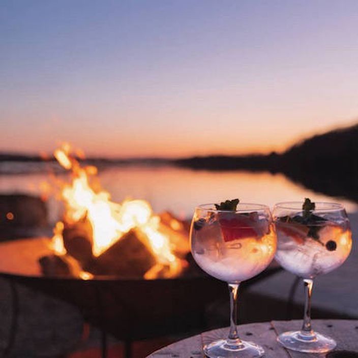 Drinks at a bonfire at a lake
