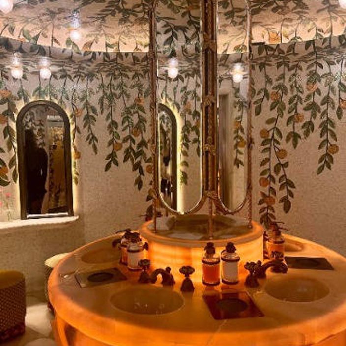 a photo of the toilet at Bacchanalia, with a round mirror 
