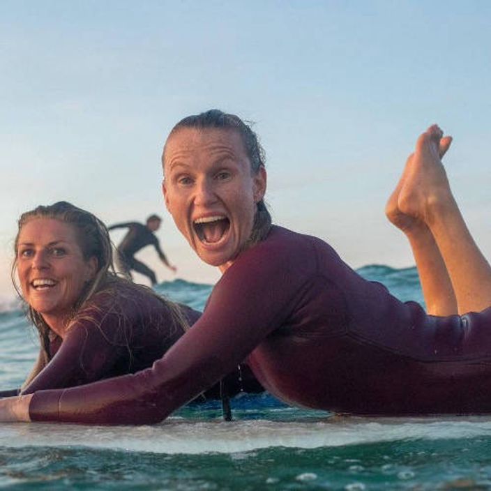 People on surf boards with friends