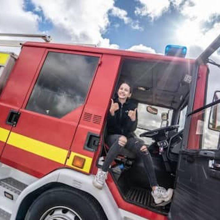 A girl smiling in a fire engine 
