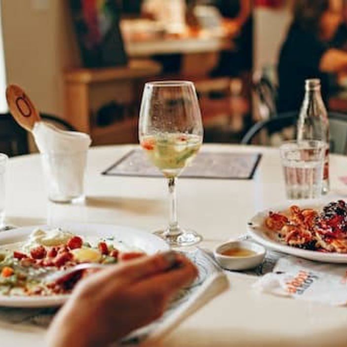 Wine in Clear Glass Near Food on Plate on Table