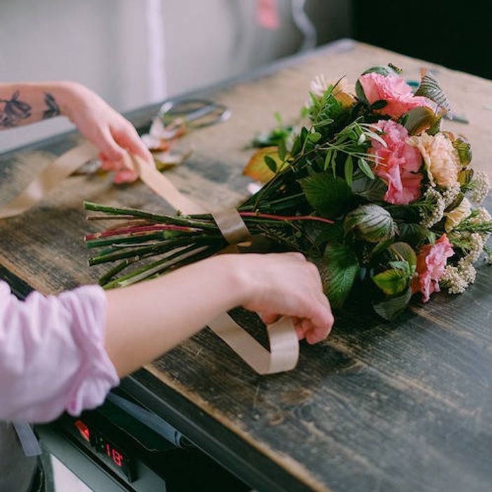 Floral bouquet being hand-tied