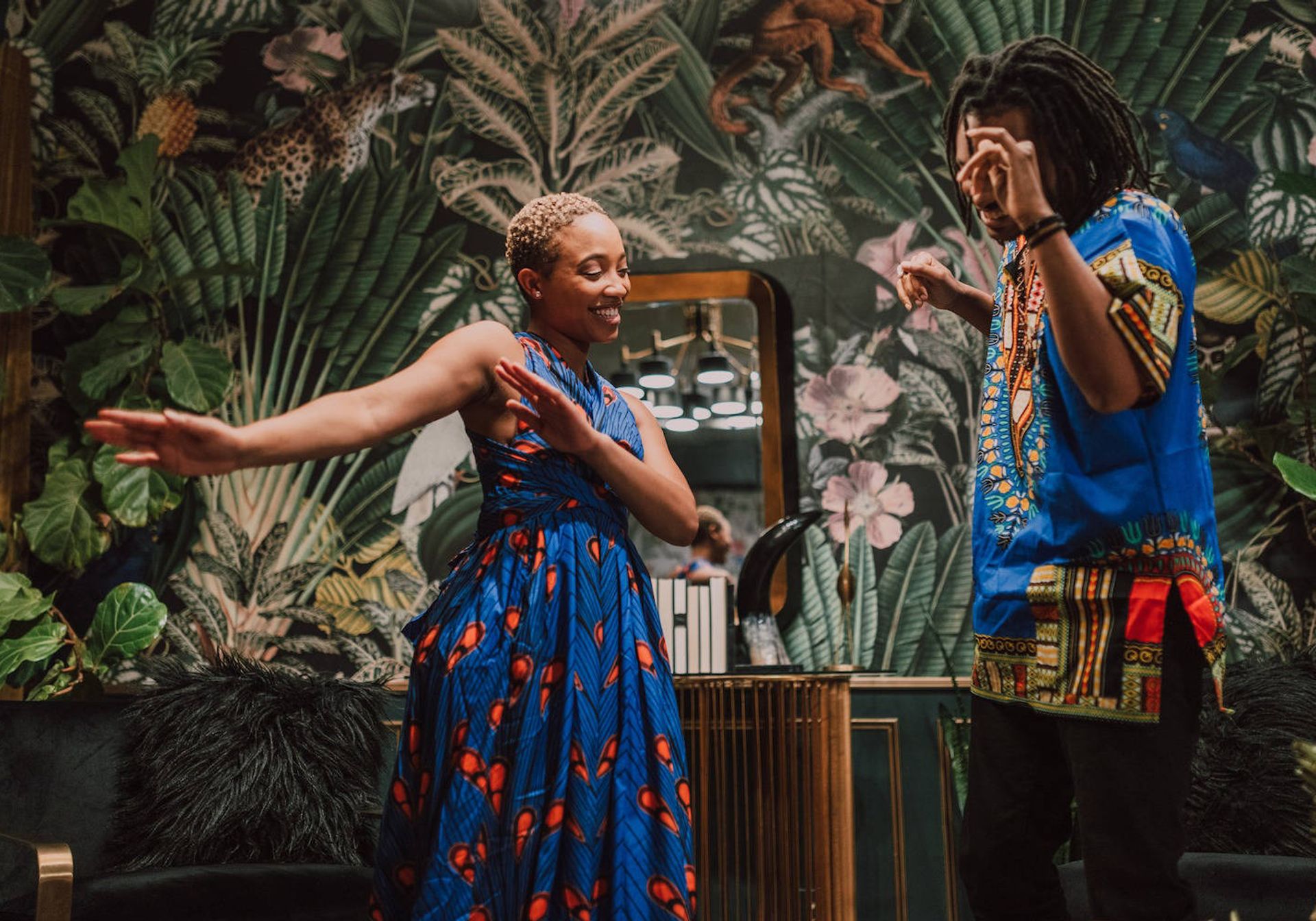 Two people dancing in a colourful room