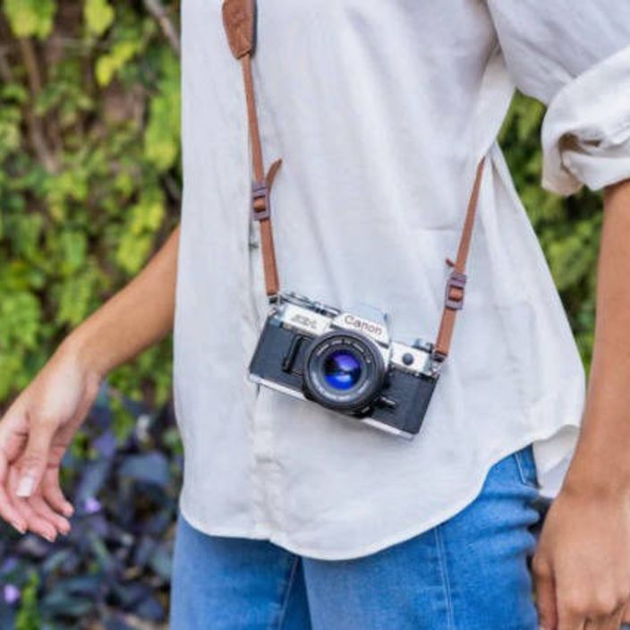 Guy wearing the Canon AE-1 camera strapped to him