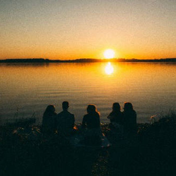 Group sitting by a lake